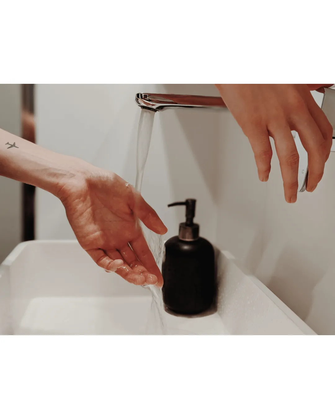 Close-up of a person washing hands with hot water