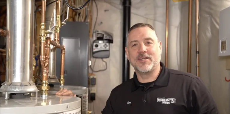 plumber showing water tank with hard-wearing, rigid polymer base preventing hot water system from damage