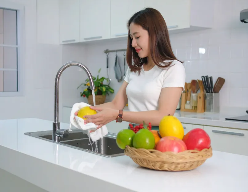 Woman washing fruit with hot water
